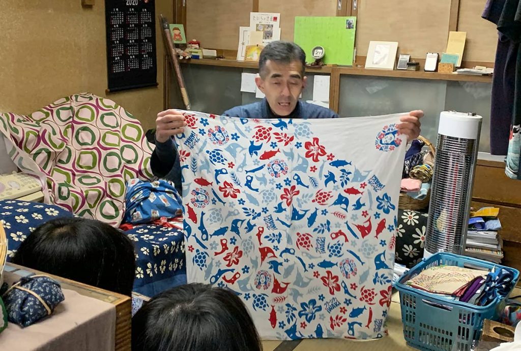 呉服店で店主の話を聞く大学生たち